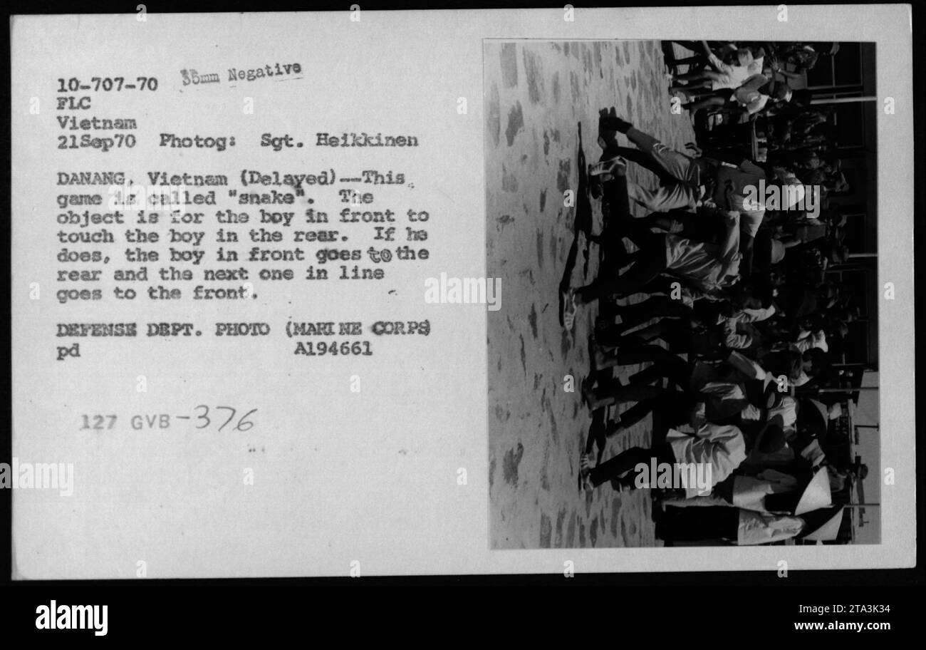 I bambini vietnamiti giocano un gioco chiamato "serpente" a Danang, in Vietnam, nel settembre 1970. Il gioco coinvolge il ragazzo davanti che tocca il ragazzo dietro, causando un cambiamento di posizione. Foto del sergente Heikkinen durante la guerra del Vietnam. Foto Stock