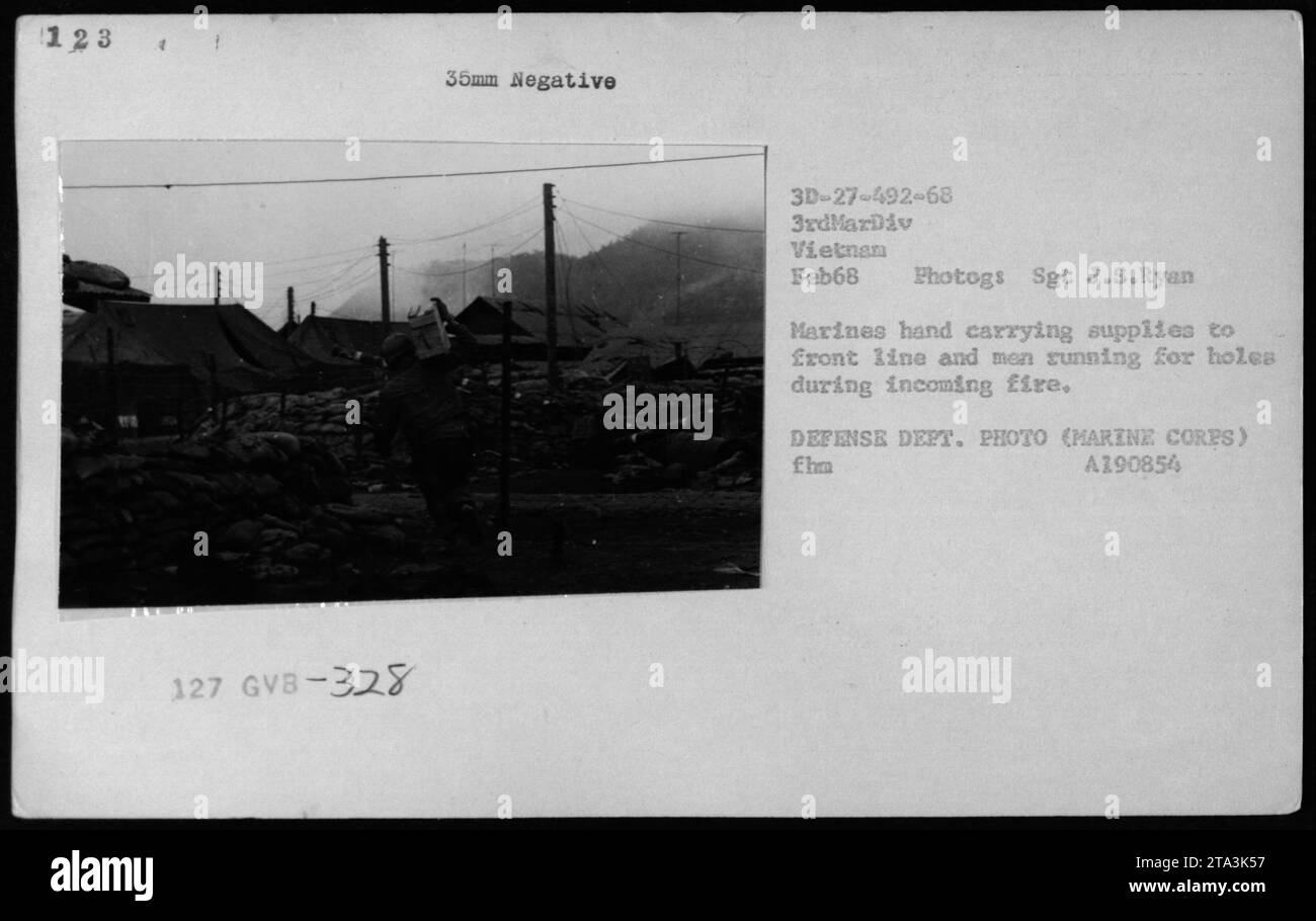 I marines nel febbraio 1968 caricano e scaricano rifornimenti pesanti sotto il fuoco in entrata in Vietnam, trasportando attrezzature in prima linea mentre prendono copertura, illustrando la logistica dei campi di battaglia e i rischi di combattimento. Foto Stock I marines nel febbraio 1968 caricano e scaricano rifornimenti pesanti sotto il fuoco in entrata in Vietnam, trasportando attrezzature in prima linea mentre prendono copertura, illustrando la logistica dei campi di battaglia e i rischi di combattimento. Foto Stock