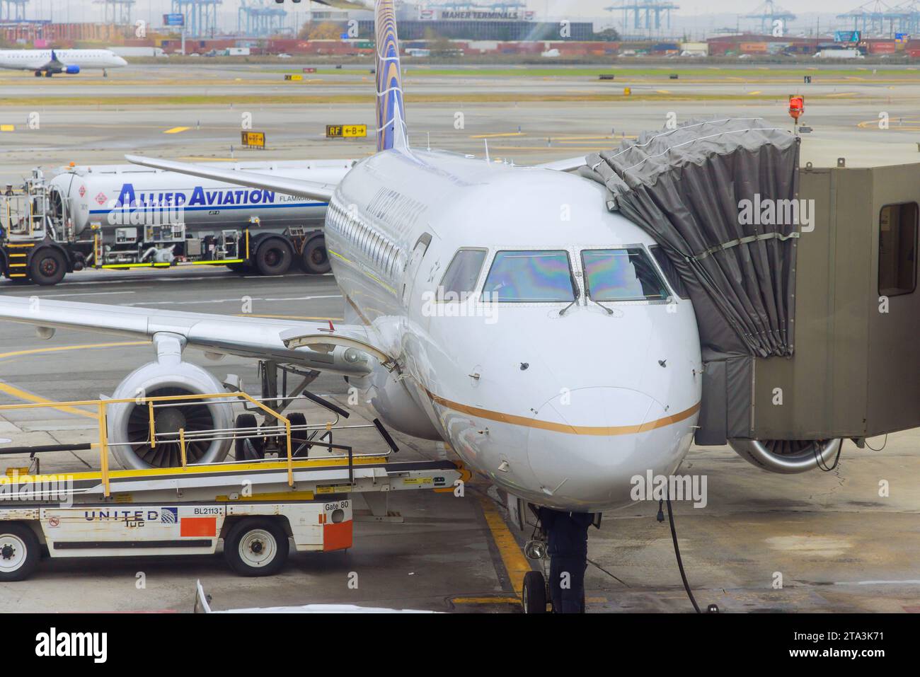 30 ottobre 2023 EWR Airport Newark NJ USA. Prima del successivo decollo, l'aereo passeggeri è servito da servizi di terra vicino al ponte del cancello d'imbarco Foto Stock