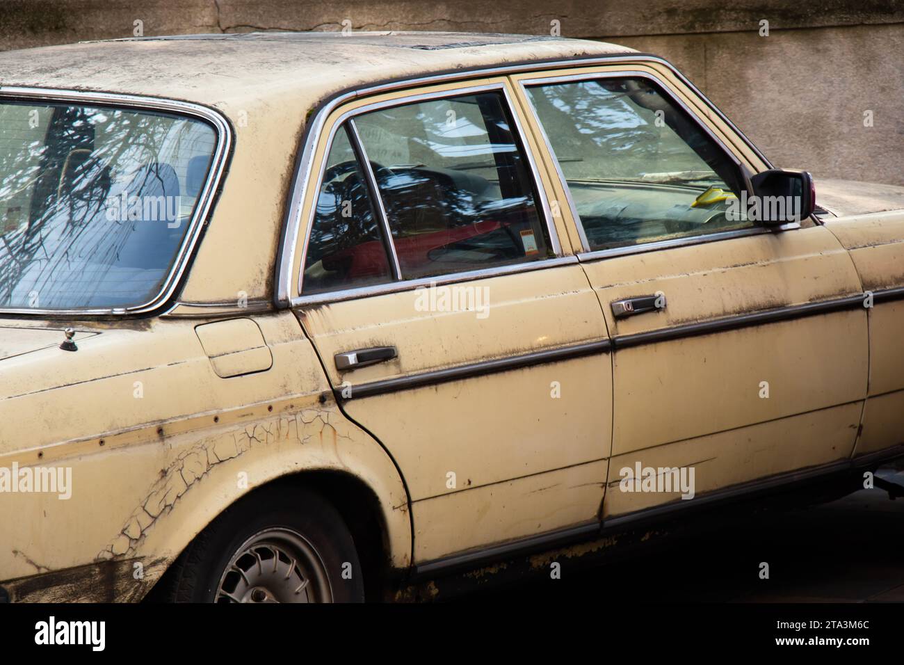 Una vecchia auto arrugginita beige parcheggiata, dettaglio Foto Stock