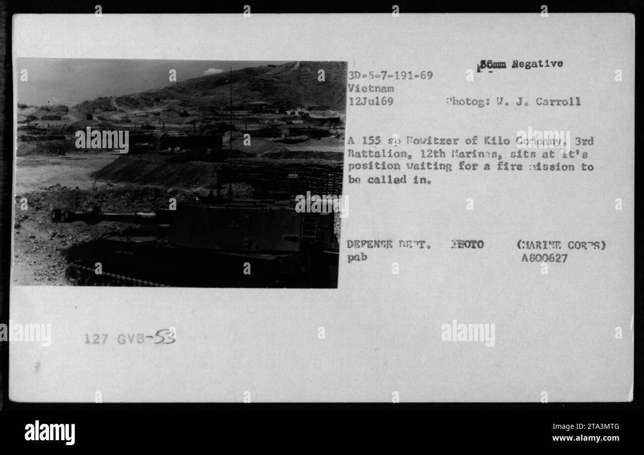 Un soldato della compagnia Kilo, 3rd Battalion, 12th Marines, gestisce un obice da 155 mm in Vietnam durante la guerra del Vietnam. Il soldato aspetta alla sua posizione che venga chiamata una missione di fuoco. Data: 12 luglio 1969. Fotografo: J. Carroll. Foto Stock