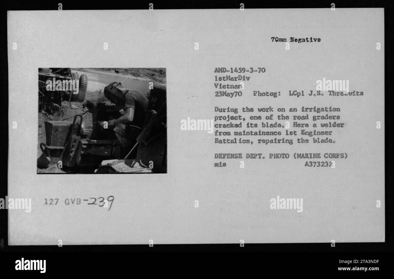 Una squadra di manutenzione del corpo dei Marines ripara una lama incrinata su un livellatore stradale durante un progetto di irrigazione in Vietnam il 23 maggio 1970, con un saldatore del Battaglione degli ingegneri che assiste. Foto Stock