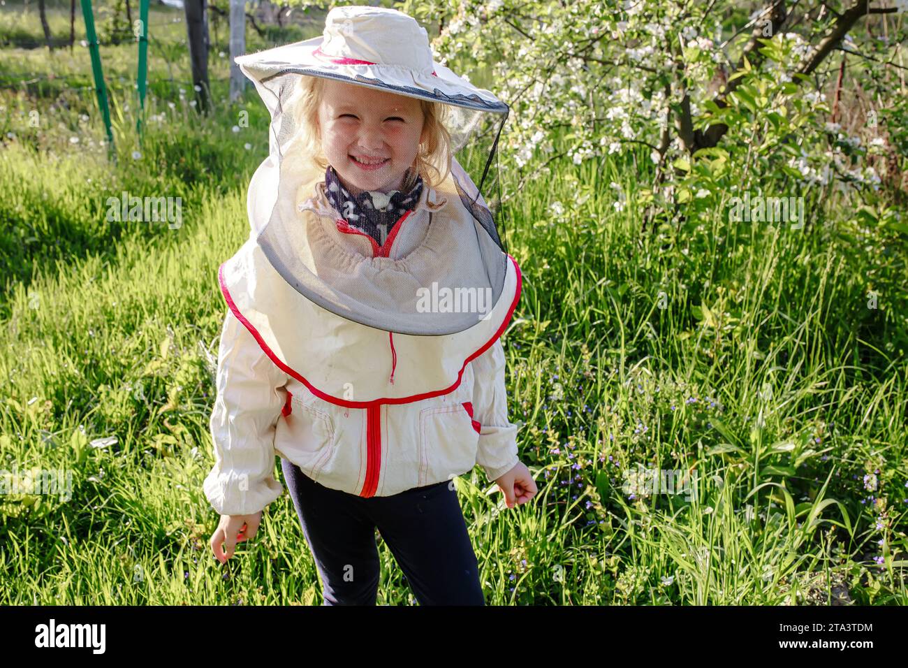 Ritratto di una bambina in costume da apicoltore. I bambini imparano a prendersi cura delle api. Foto Stock