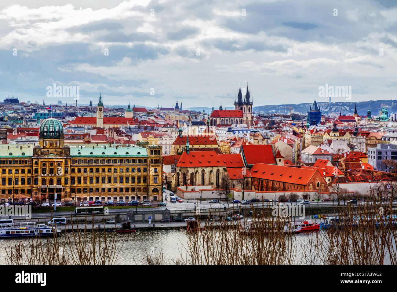 Vista aerea invernale sulla città vecchia di Praga. Tetti con tegole rosse. Barche da turismo ormeggiate sulla riva del fiume Moldava e parte del Ministero dell'industria e del Foto Stock