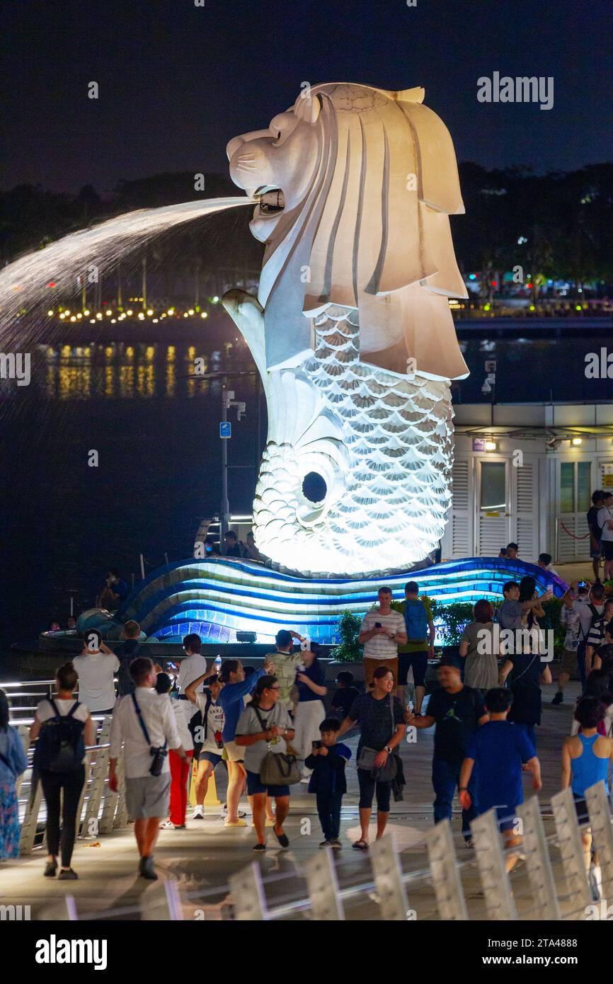Una vista notturna della statua di Merlion su Marina Bay a Singapore, vista dal ponte pedonale Jubilee. Foto Stock