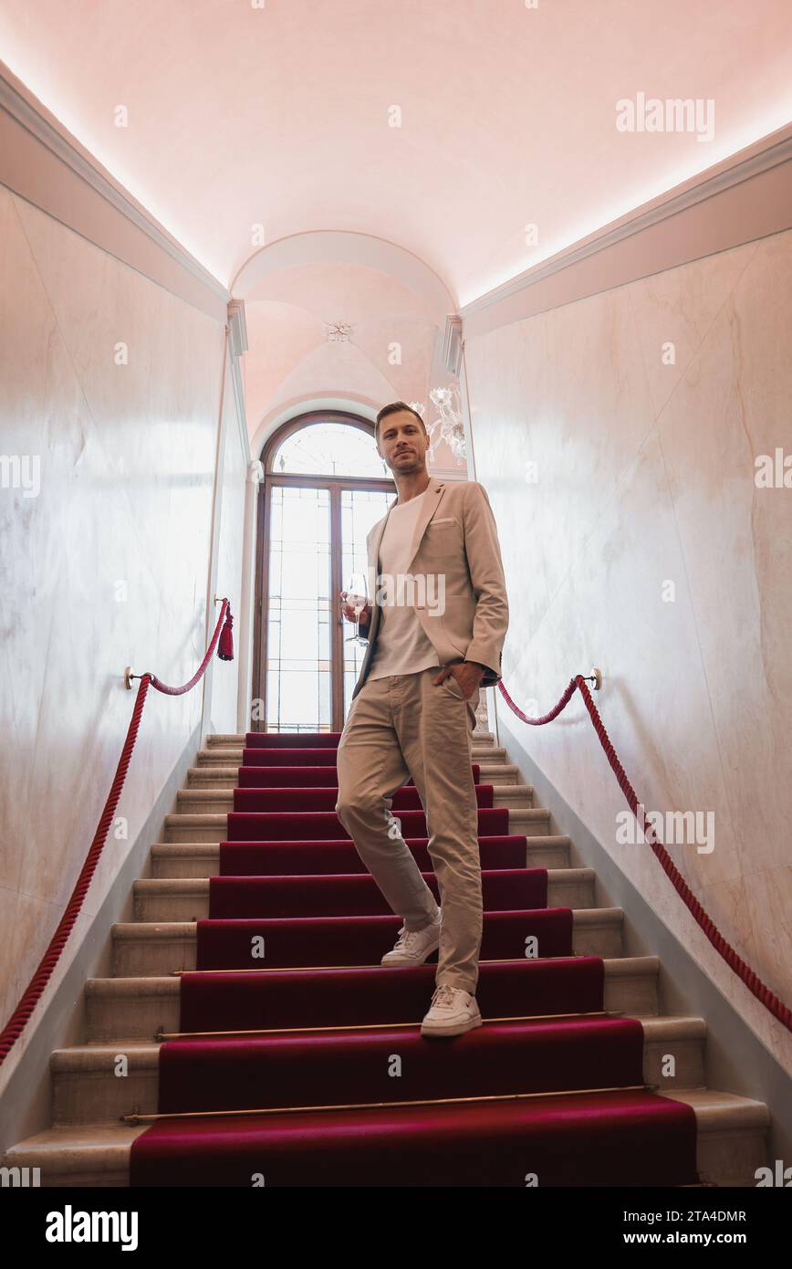 Uomo d'affari sicuro di sé in piedi sulle scale dell'edificio veneziano a Venezia, Italia. Foto Stock