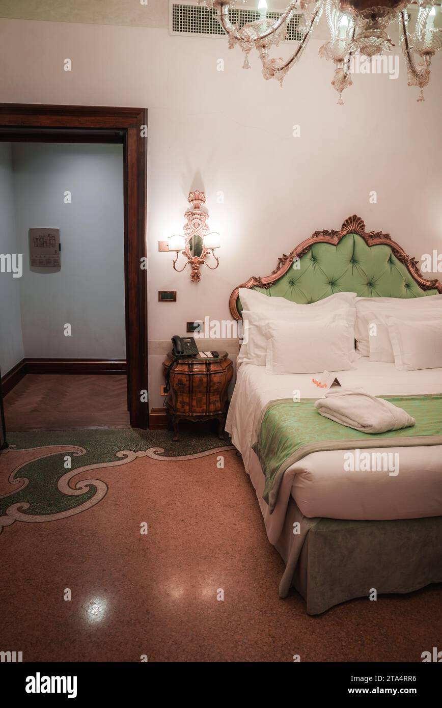 Lussuose camere d'hotel in stile tradizionale con accenti verdi e oro e pavimento in marmo a Venezia Foto Stock