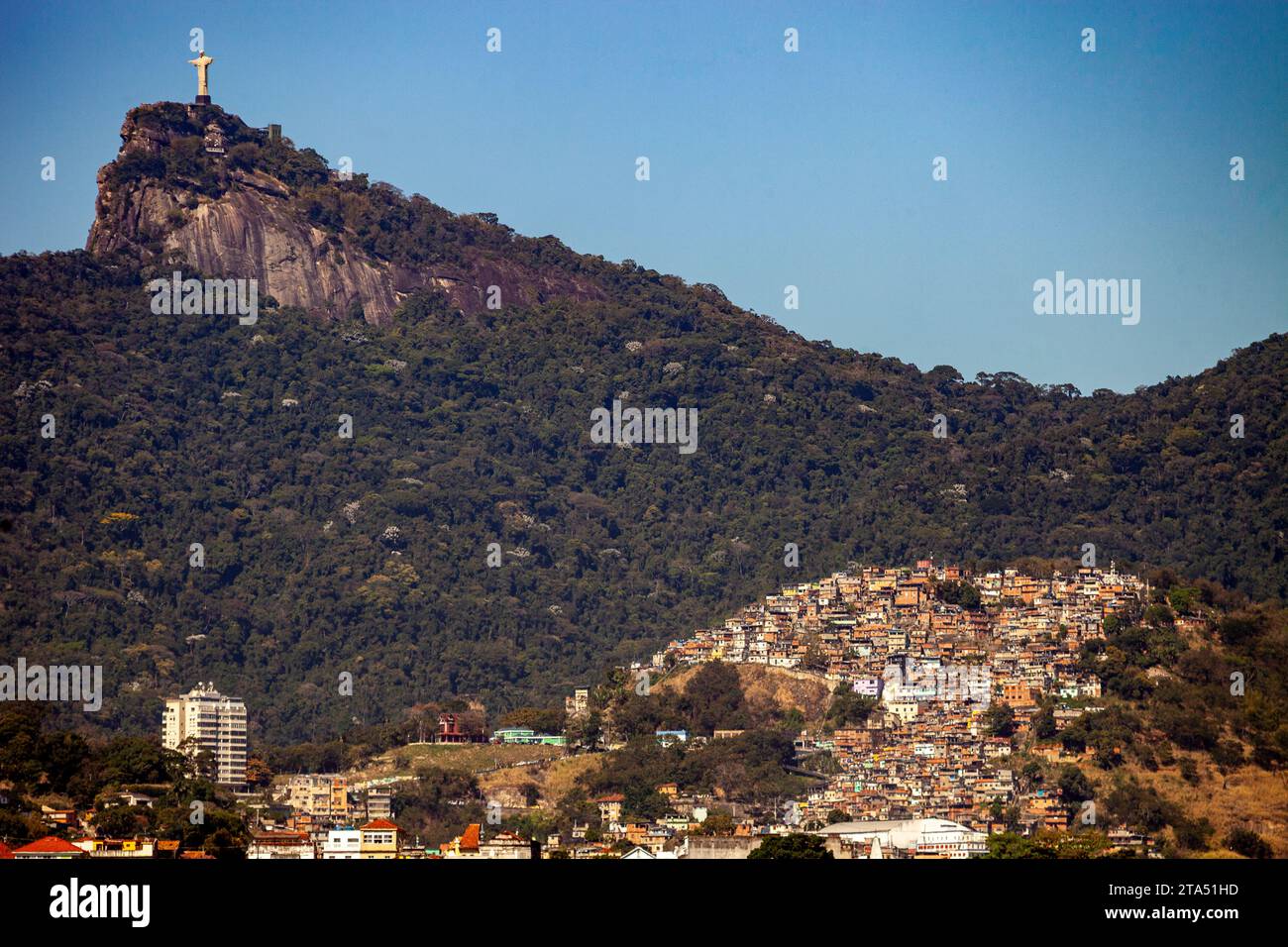 Statua del Cristo Redentore in cima al monte Corcovado, circondata dalla foresta di Tijuca e dalle favelas. Foto Stock