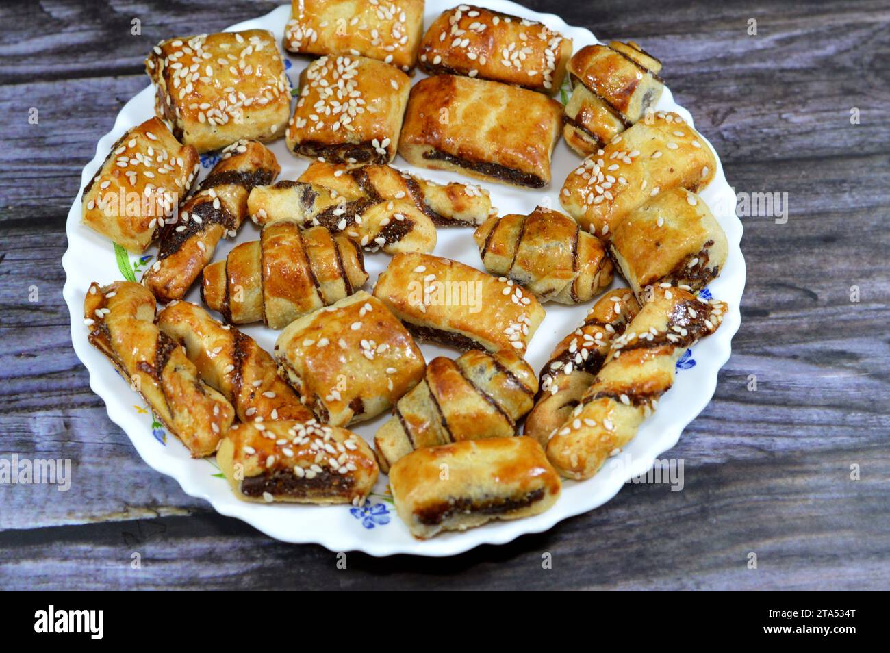 Pasta farcita con datteri e condita con semi di sesamo o Ka'ab El Ghazal, datteri egiziani o biscotti ripieni di Agwa Ajwa, famosa fille di datteri mediorientali Foto Stock