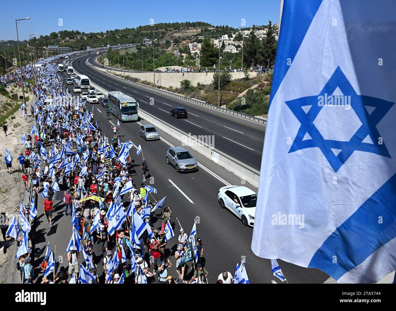 Abu Gosh, Israele. 22 luglio 2023. Decine di migliaia di manifestanti israeliani sventolano la bandiera nazionale durante una marcia verso Gerusalemme contro i piani del governo del primo ministro Benjamin Netanyahu di rivedere il sistema giudiziario, su un'autostrada vicino ad Abu Gosh, sabato 22 luglio 2023. I manifestanti si insedieranno nei pressi della Knesset israeliana, il Parlamento, in un ultimo tentativo di fermare il disegno di legge per la revisione giudiziaria. Foto di Debbie Hill/ Credit: UPI/Alamy Live News Foto Stock