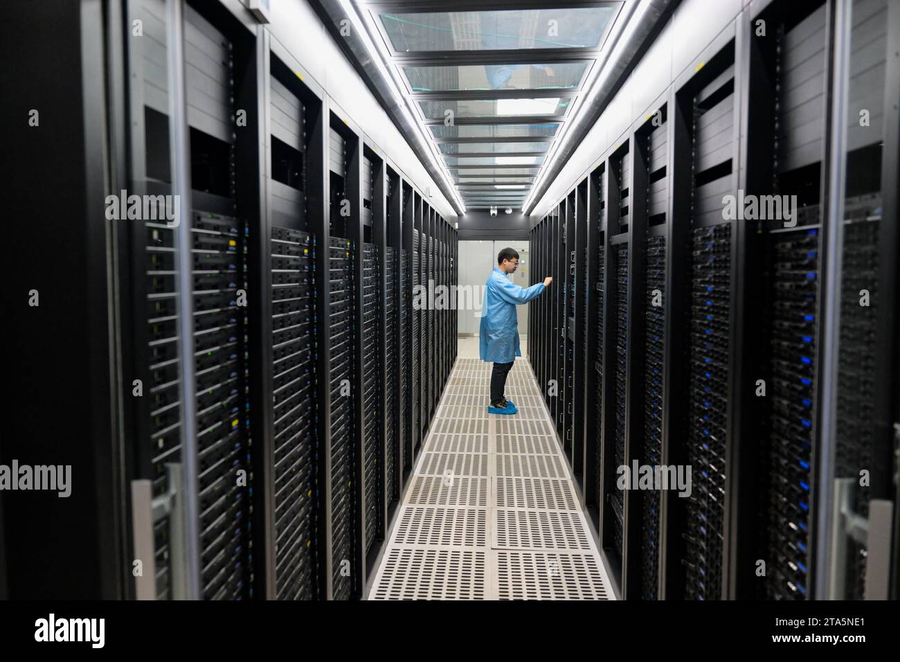 Hohhot, la Mongolia interna cinese. 28 novembre 2023. Un membro del personale controlla le apparecchiature di una società di calcolo ad alte prestazioni a Horinger, Hohhot City, nella Mongolia interna della Cina settentrionale, 28 novembre 2023. Il cluster di data center Horinger, situato nella città di Hohhot, nella Mongolia interna della Cina settentrionale, può ospitare circa 950.000 server, collocandolo tra i principali data center in Cina in termini di potenza di elaborazione. Crediti: Li Zhipeng/Xinhua/Alamy Live News Foto Stock