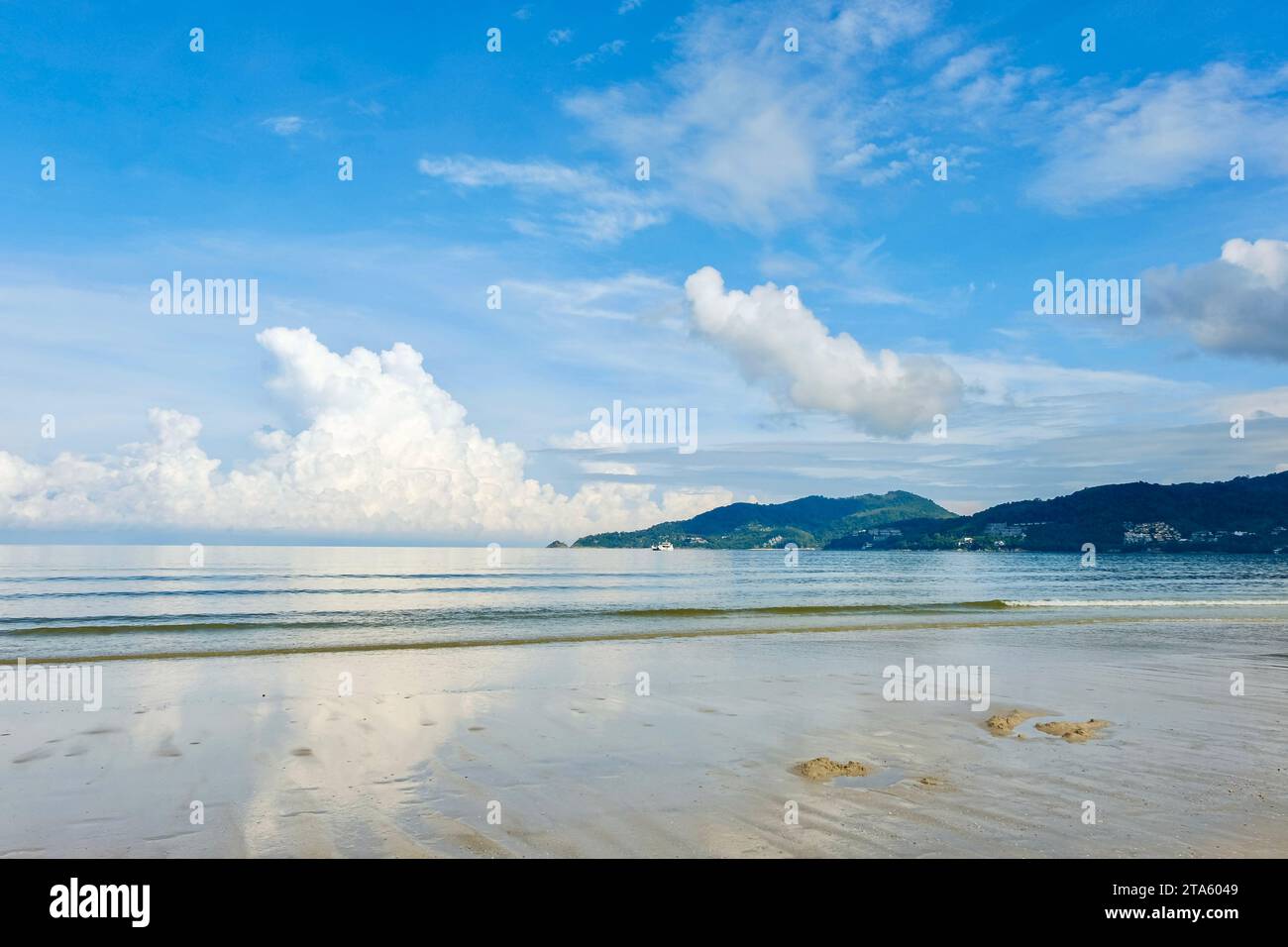Una mattinata di sole a Patong Beach, con soffici nuvole bianche e cieli blu riflessi nelle acque limpide del Mare delle Andamane - Phuket, Thailandia Foto Stock