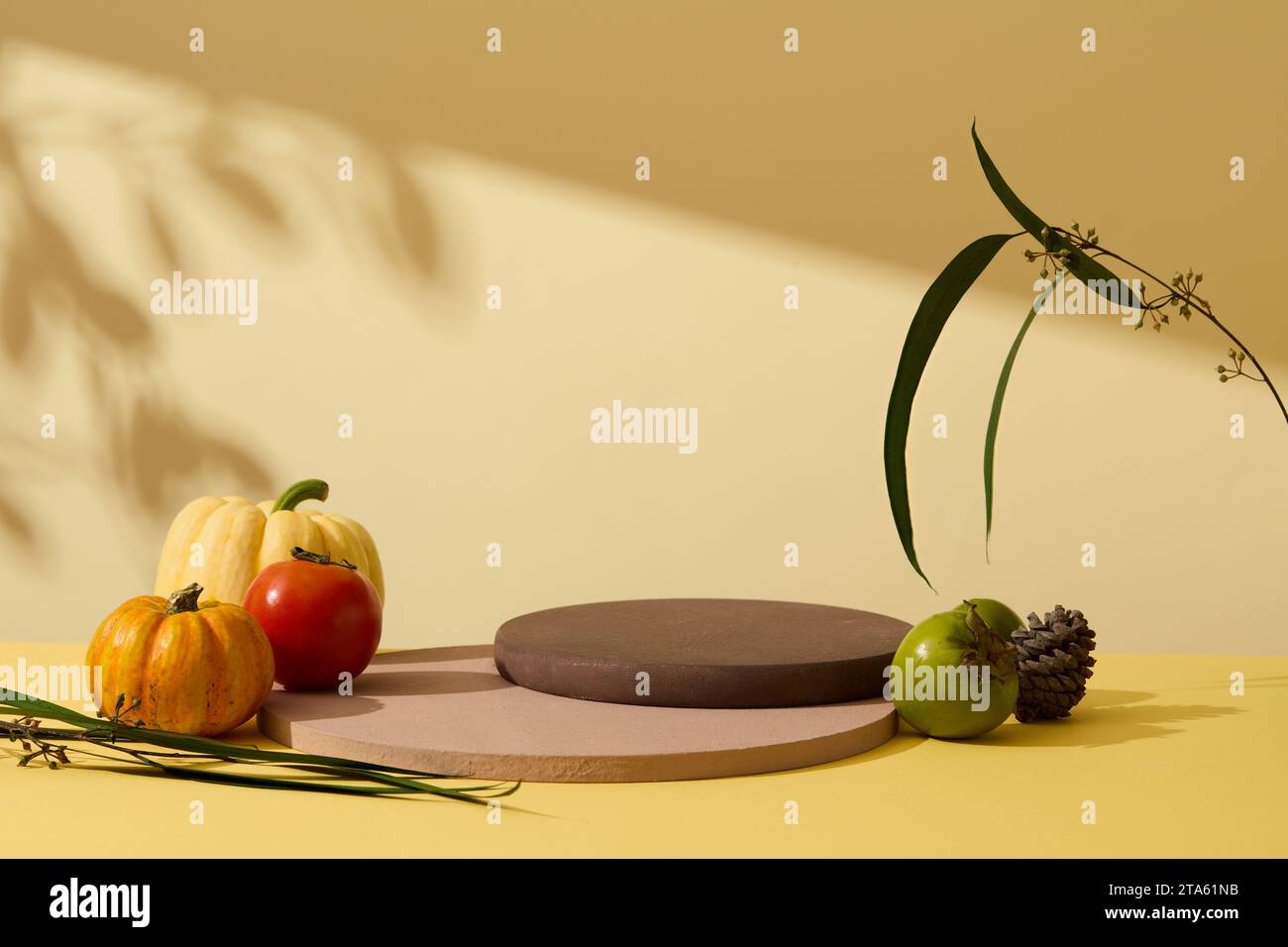 Scena minima astratta per il prodotto pubblicitario con spazio vuoto sulla pila di podi su sfondo giallo con sfondo giallo. Zucche, pomodoro e. Foto Stock