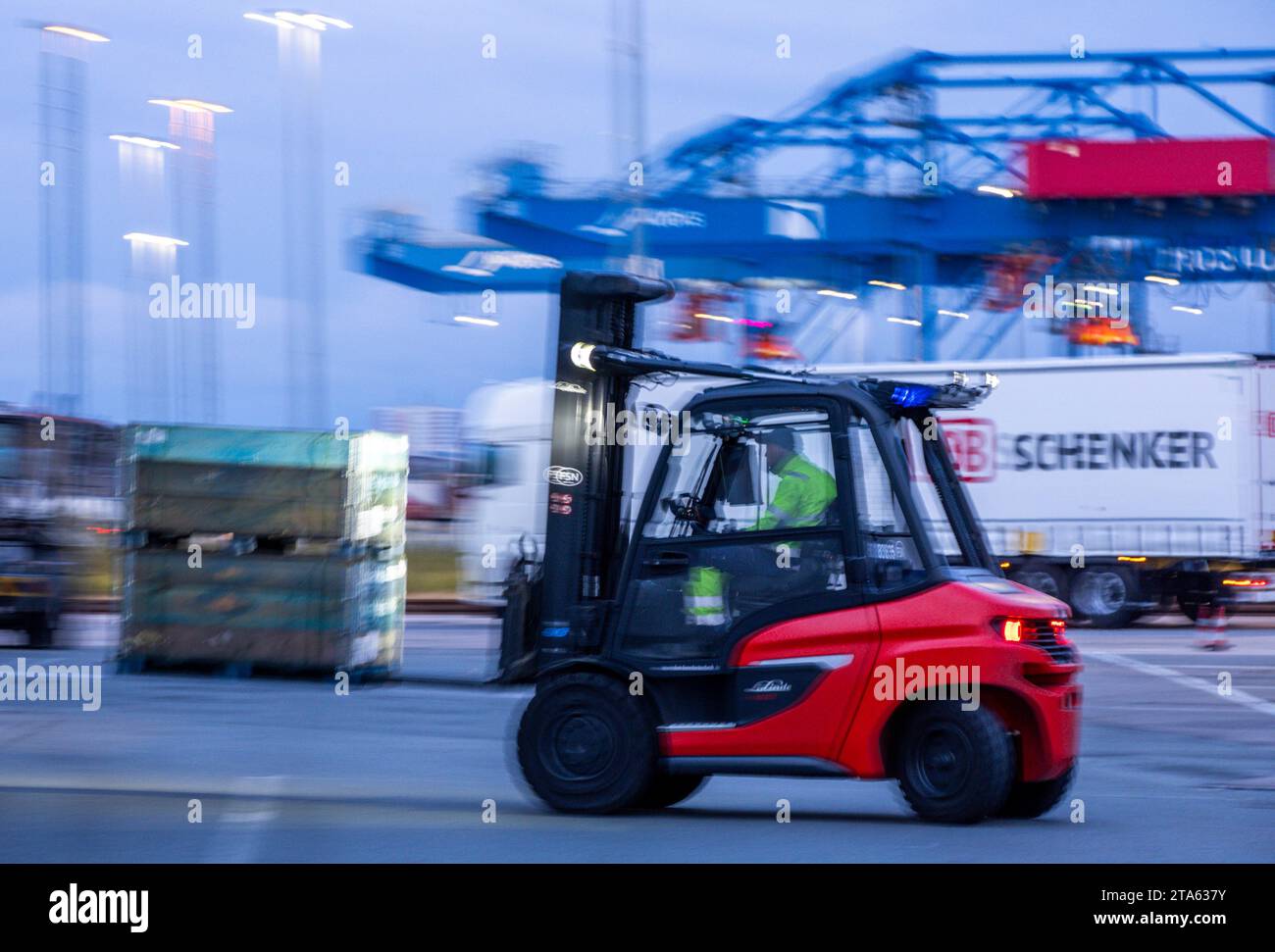 Rostock, Germania. 21 novembre 2023. I pallet e le merci trasportate vengono scaricati da rimorchi appartenenti alla società di logistica DB Schenker sul sito del centro logistico nel porto marittimo. La filiale logistica di Deutsche Bahn gestisce diversi centri logistici nel Meclemburgo-Pomerania. Credito: Jens Büttner/dpa/Alamy Live News Foto Stock