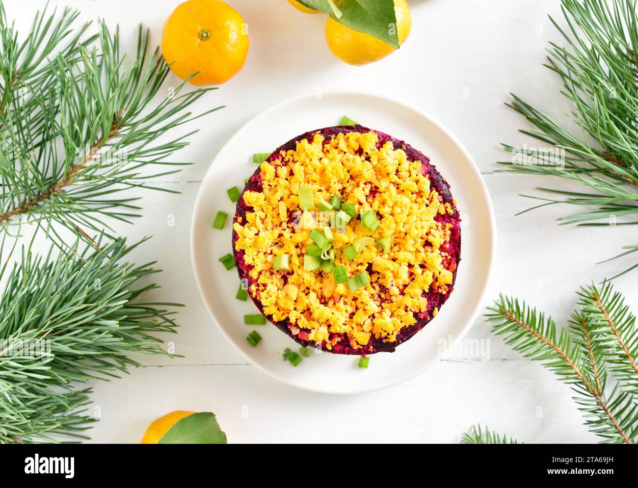 Insalata Shuba. Aringhe vestite, aringhe sotto il cappotto di pelliccia. Insalata di verdure a strati natalizia con aringhe e verdure bollite. Sfondo di legno bianco wi Foto Stock