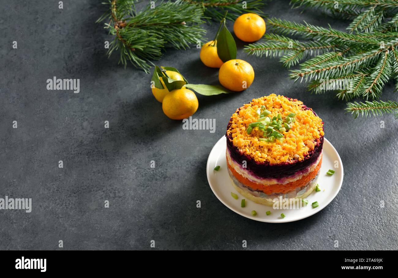 Insalata Shuba. Aringhe vestite, aringhe sotto il cappotto di pelliccia. Insalata di verdure a strati natalizia con aringhe e verdure bollite. Sfondo scuro con libero Foto Stock