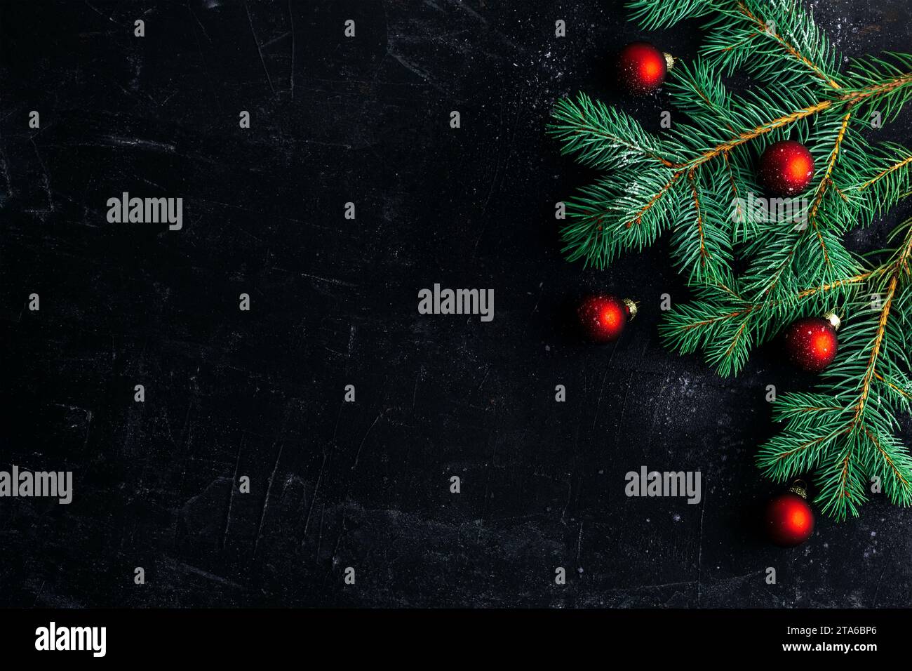 Sfondo natalizio natalizio con rami di abete e palline rosse. Vista dall'alto, base piatta, spazio di copia. Foto Stock