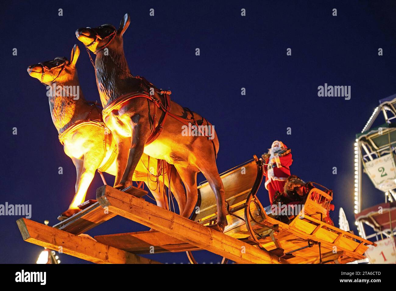 AM Rande des Bremer Weihnachtsmarkts, auf dem Domshof, schwebt der Weihnachtsmann mit seinem Rentierschlitten durch die Luft. *** Ai margini del mercato di Natale di Bremens, sul Domshof, Babbo Natale galleggia nell'aria nella sua slitta di renna Foto Stock