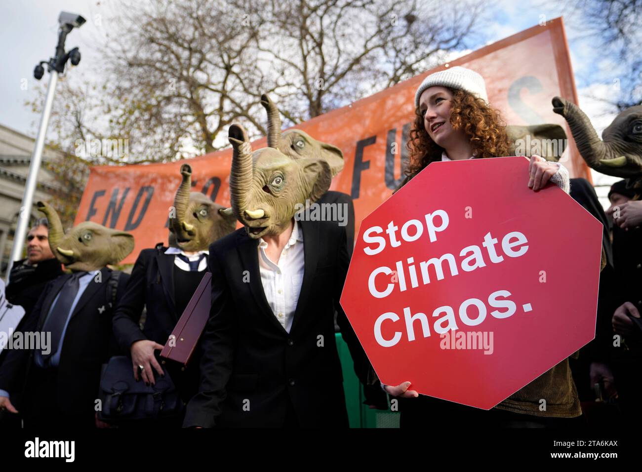 Fermare i membri del caos climatico, vestiti da CEO della Big Oil, con abiti da lavoro neri e con maschere di elefante fuori dalla Leinster House di Dublino per avvertire il governo irlandese che non deve lasciare che i combustibili fossili distruttivi dal clima siano l'elefante nella stanza dei colloqui sul clima della COP28 delle Nazioni Unite. Data foto: Mercoledì 29 novembre 2023. Foto Stock