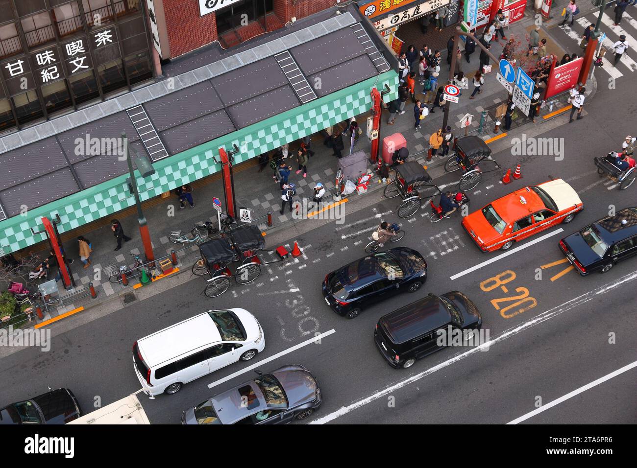 TOKYO, GIAPPONE - 4 DICEMBRE 2016: Pedoni, automobili e conducenti di risciò condividono la strada di Asakusa a Tokyo, Giappone. Foto Stock