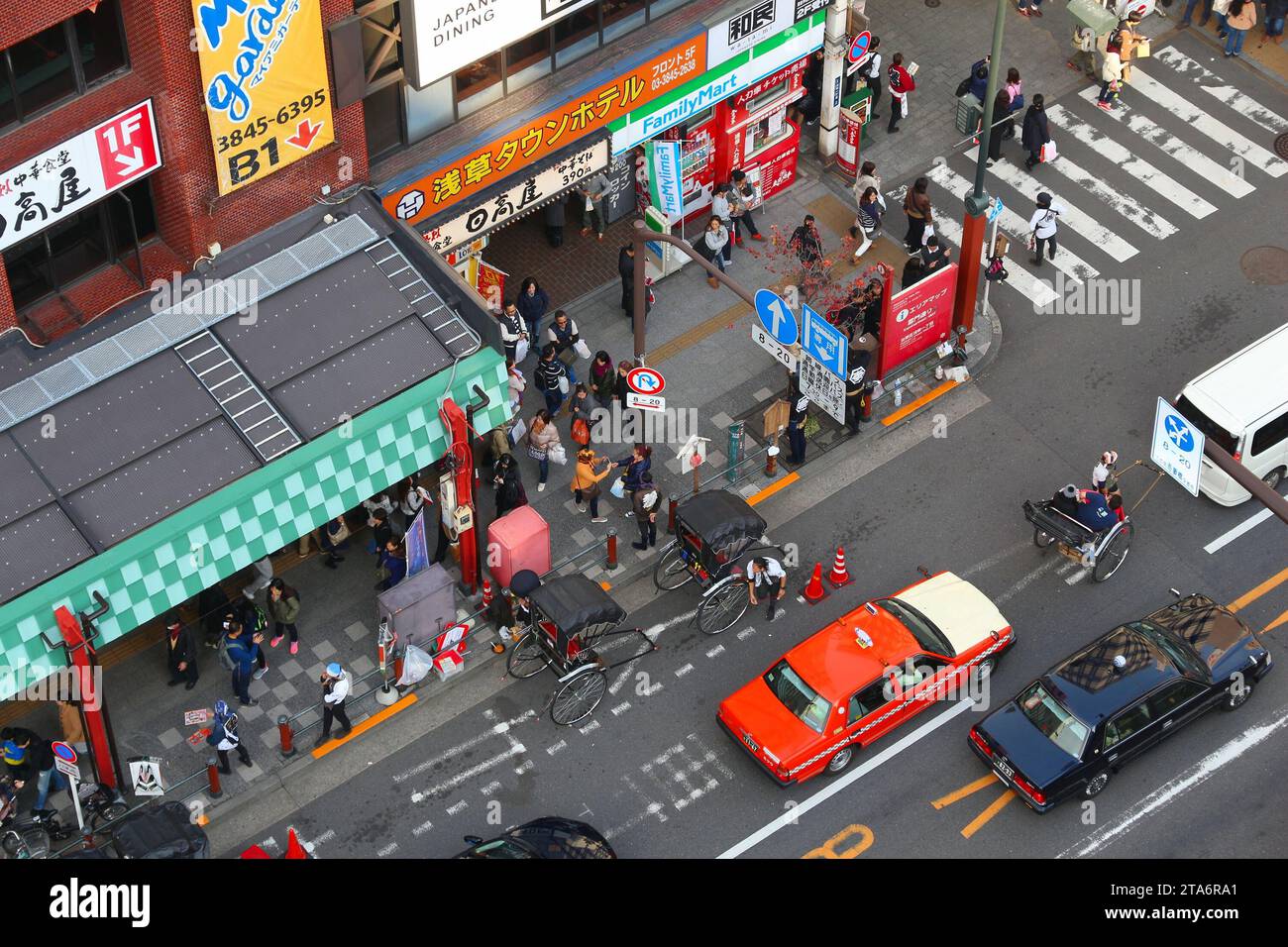 TOKYO, GIAPPONE - 4 DICEMBRE 2016: Pedoni, automobili e conducenti di risciò condividono la strada di Asakusa a Tokyo, Giappone. Foto Stock