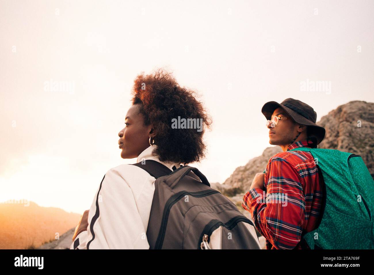 Giovani uomini e donne che viaggiano con lo zaino in spalla che guardano lontano in vacanza Foto Stock