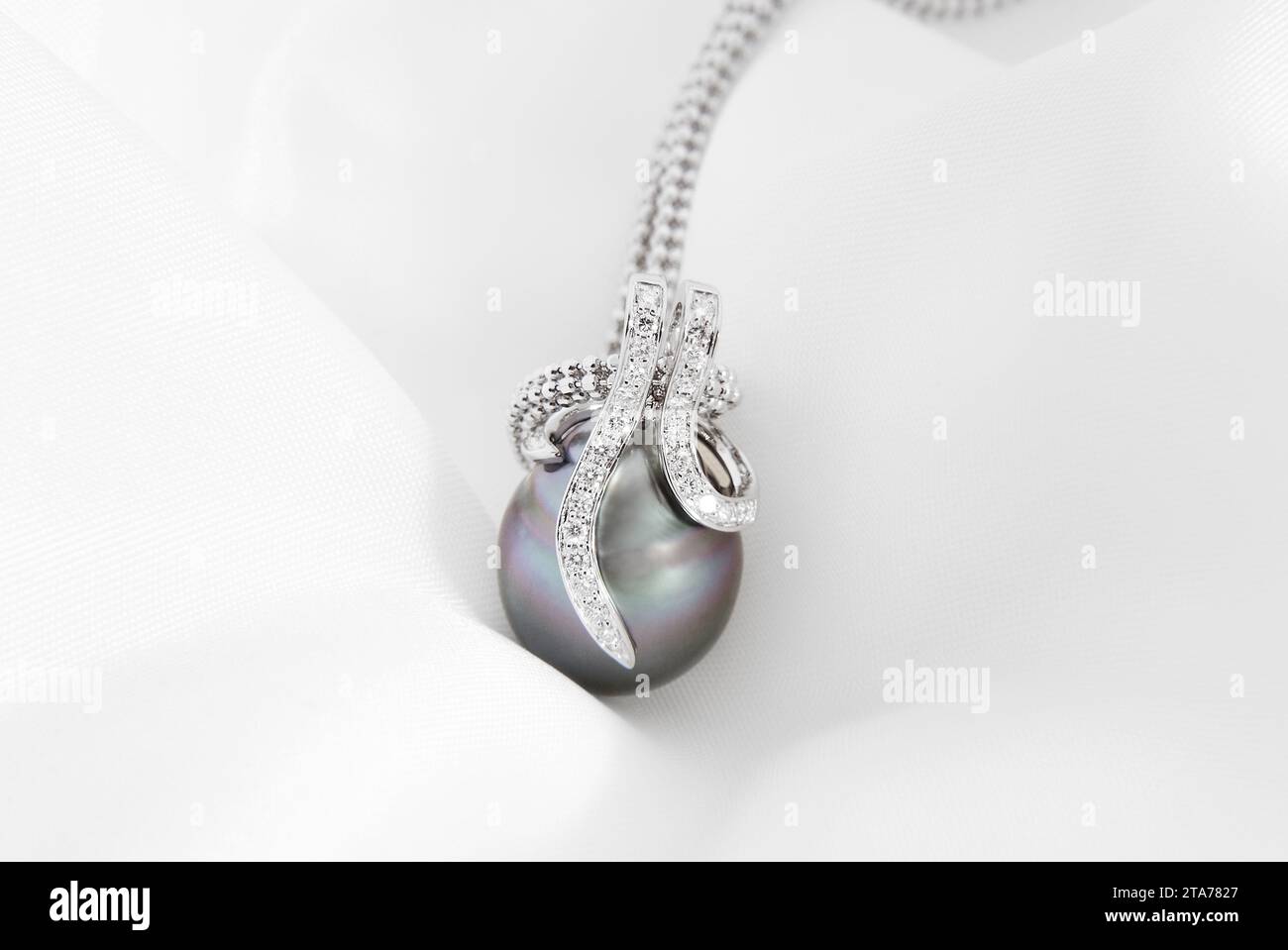 Caratterizzata da una lussureggiante perla di Tahiti, questa lampada a sospensione è realizzata in oro bianco con un alone tempestato di diamanti, che incarna la raffinatezza Foto Stock