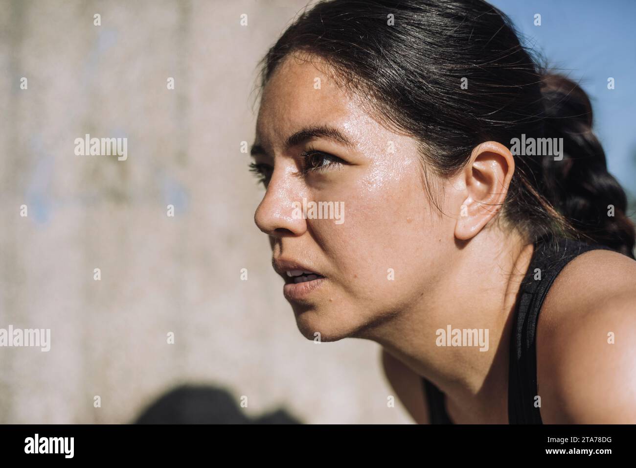 Donna esausta che si prende una pausa mentre si allena nelle giornate di sole Foto Stock