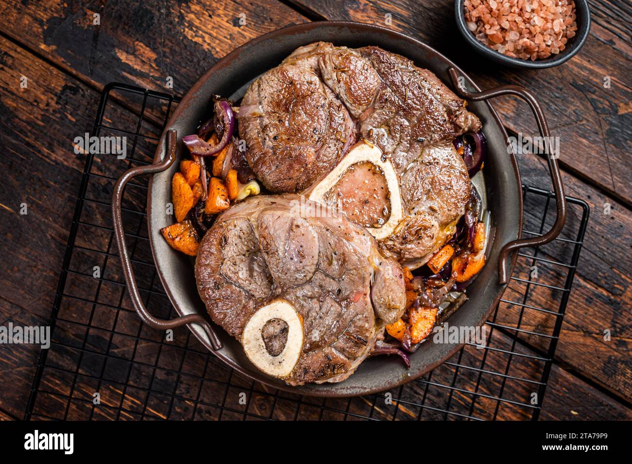 Stufato di vitello osso Buco, bistecca di carne all'ossobuco italiana. Sfondo di legno. Vista dall'alto. Foto Stock