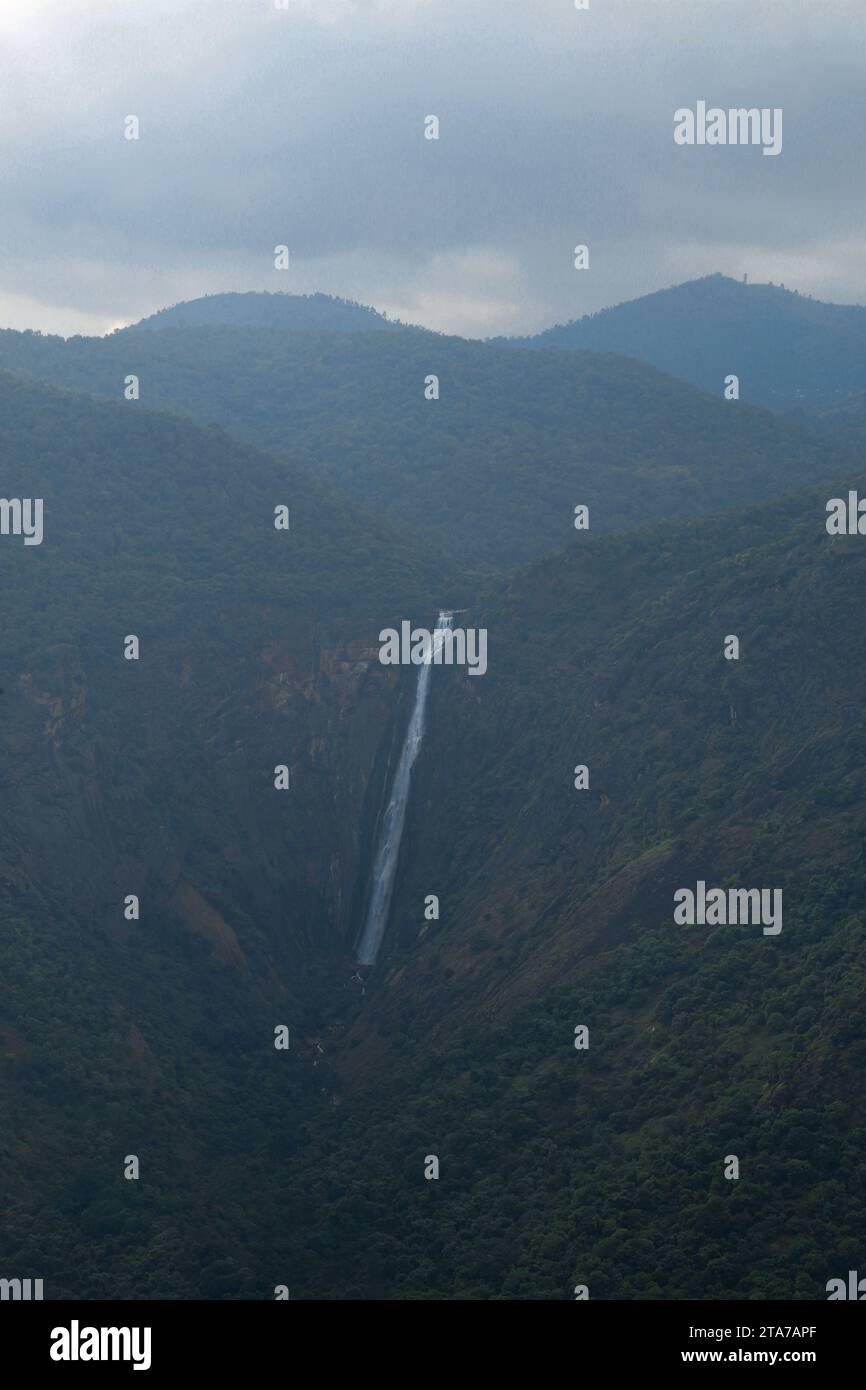 Maestosa catena montuosa tra nebbia nebulizzata e cascata in una natura serena Foto Stock
