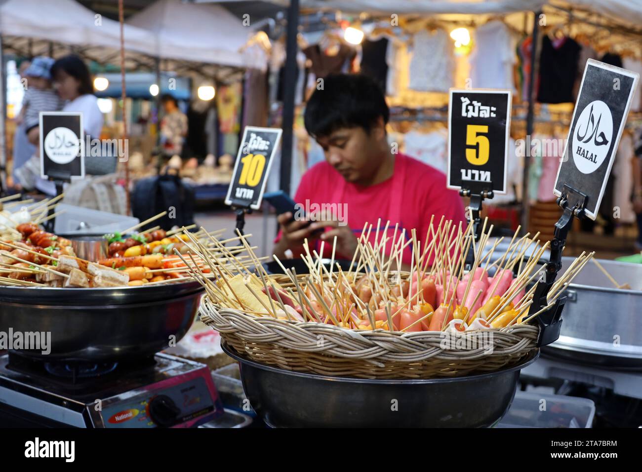 Tailandese che vende spuntini di carne al mercato notturno per i turisti Foto Stock