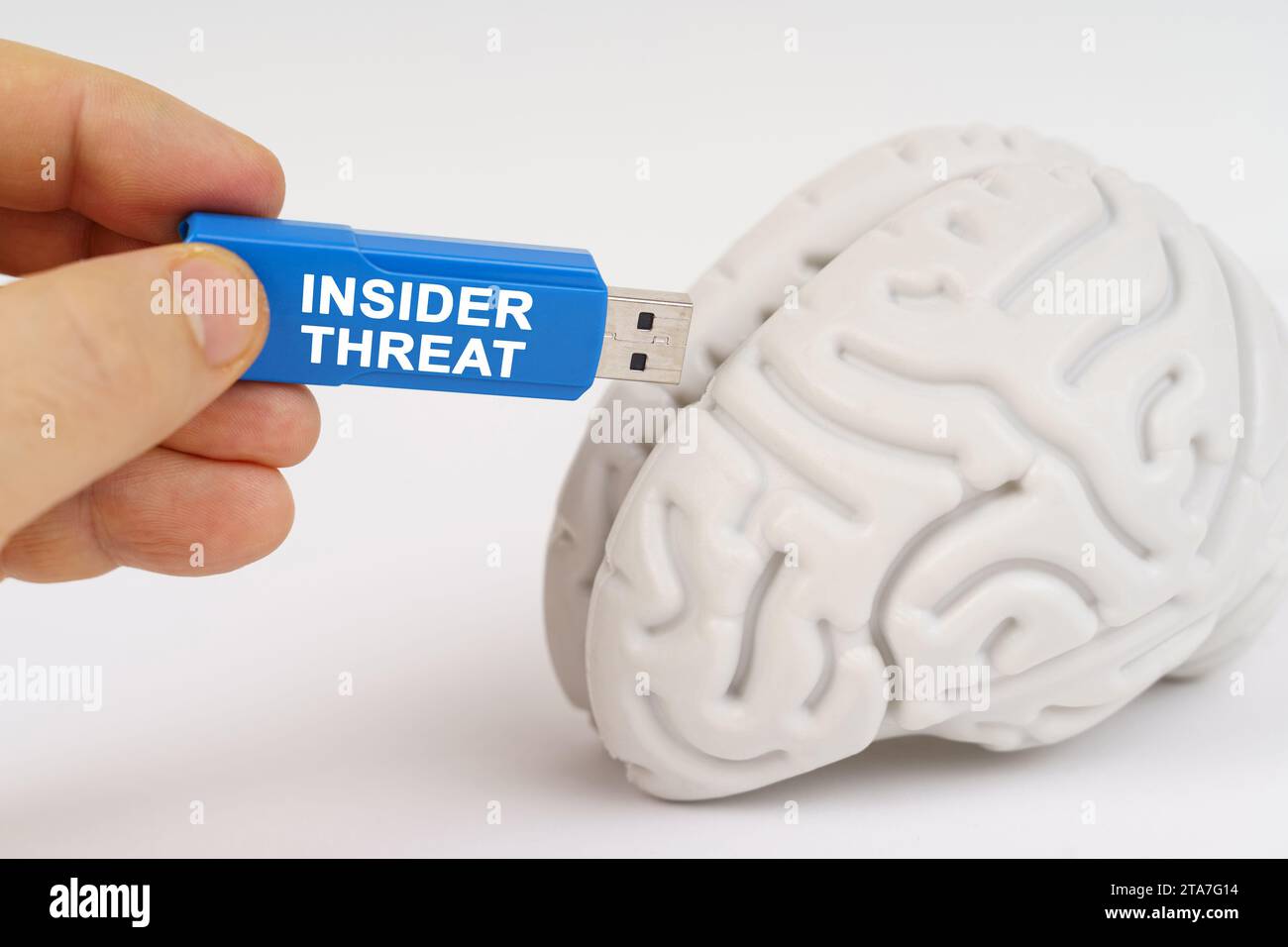 Un uomo inserisce una chiavetta nel suo cervello con l'iscrizione "INSIDER THREAT". Concetto aziendale e tecnologico. Foto Stock