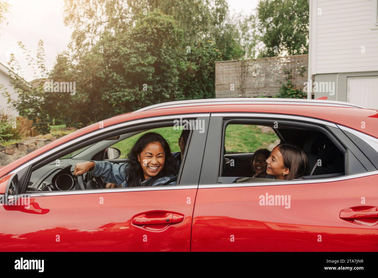 La famiglia si diverte in auto elettrica durante il viaggio in auto Foto Stock