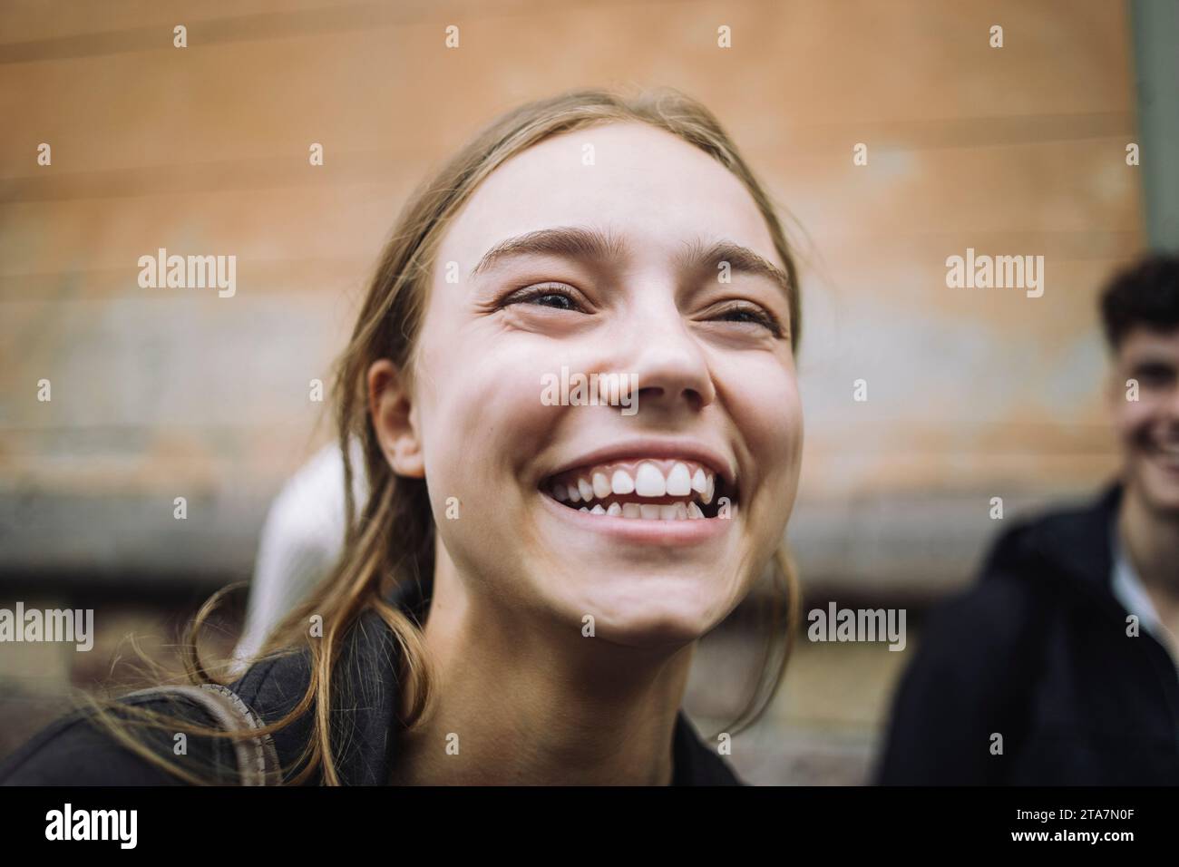 Felice ragazza adolescente che ride con gli amici in strada Foto Stock