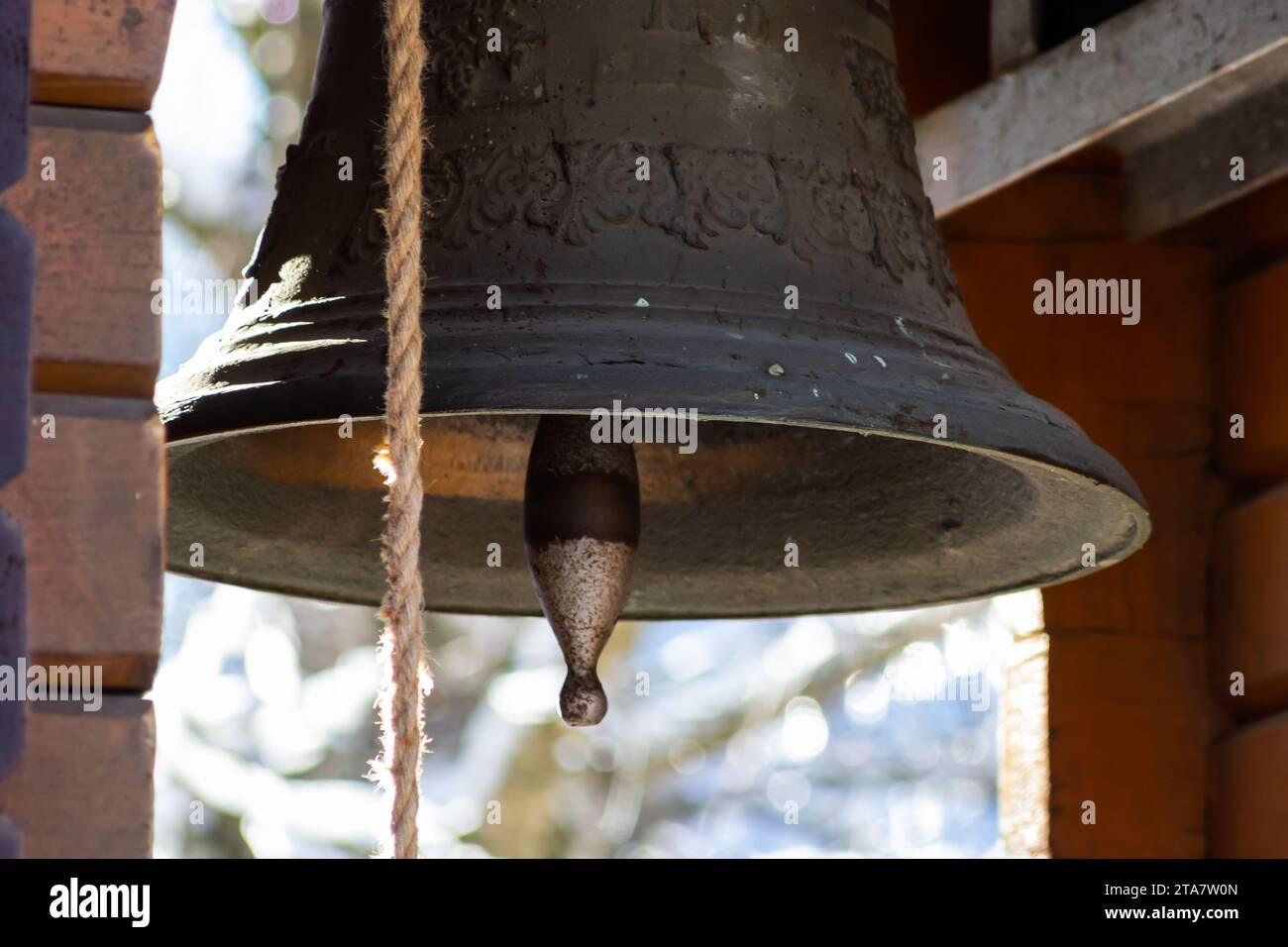 Vista delle montagne innevate, attraverso la campana della chiesa, che si trova nel piccolo villaggio di Kryvorivnya nei Carpazi ucraini. Foto Stock