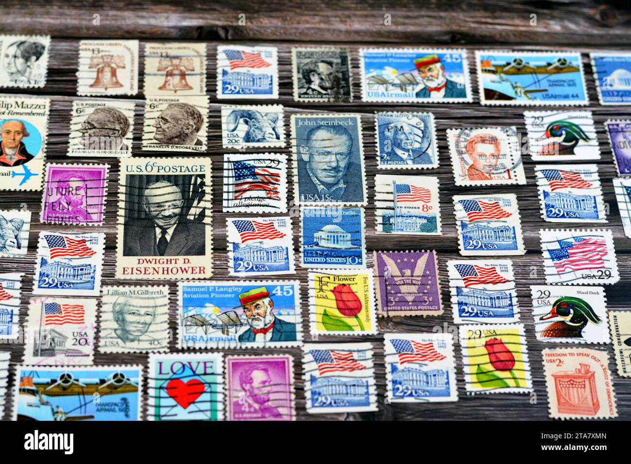 Cairo, Egitto 21 settembre 2022: Vari vecchi francobolli usati dagli Stati Uniti d'America in tempi diversi su uno sfondo di legno, con una copertina Foto Stock
