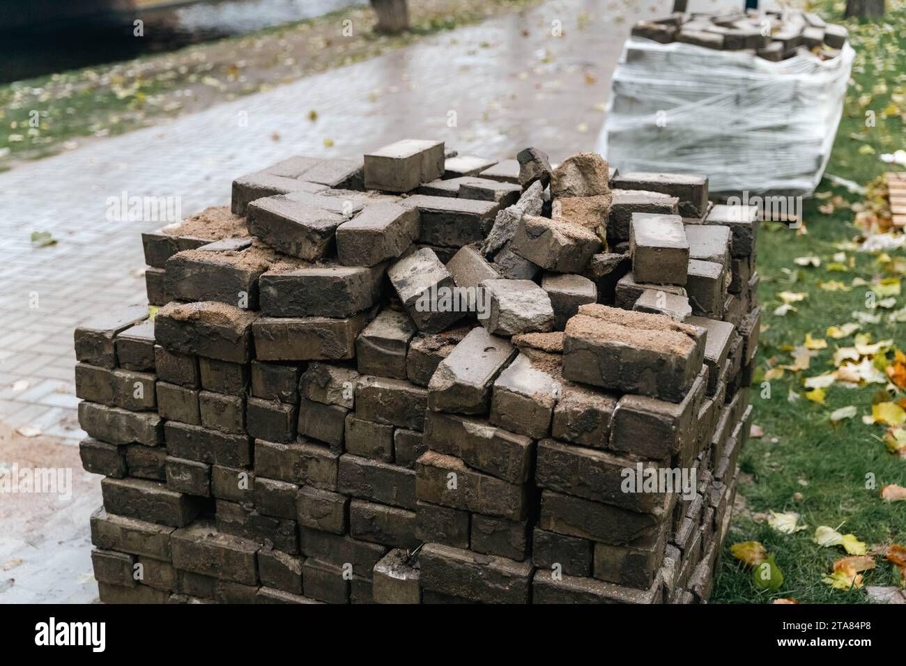 Urban Renewal: DilapA pile di lastre di pavimentazione usurate e rotte impilate per strada, durante un progetto di rinnovamento urbano del centro. Le lastre intemprate sono sur Foto Stock