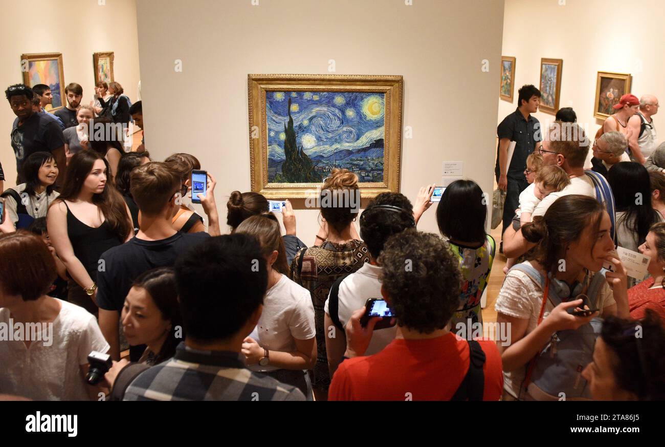 New York, Stati Uniti d'America - 25 maggio 2018: Folla di persone vicino alla notte stellata di Vincent van Gogh dipingendo nel Museo di Arte moderna di New York City. Foto Stock