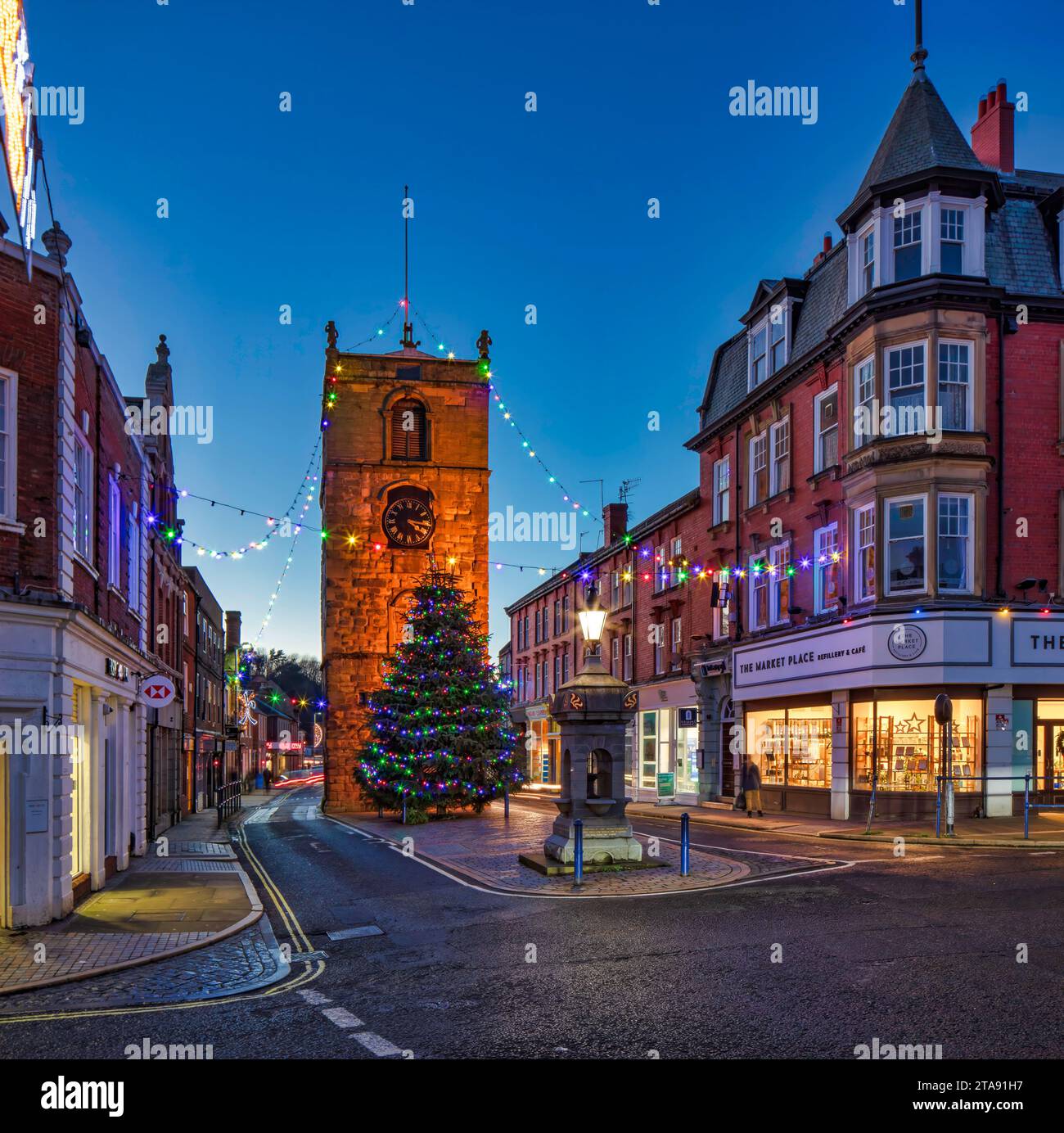 Le luci natalizie si illuminano al crepuscolo a Morpeth, Northumberland, guardando verso la torre dell'orologio illuminata Foto Stock