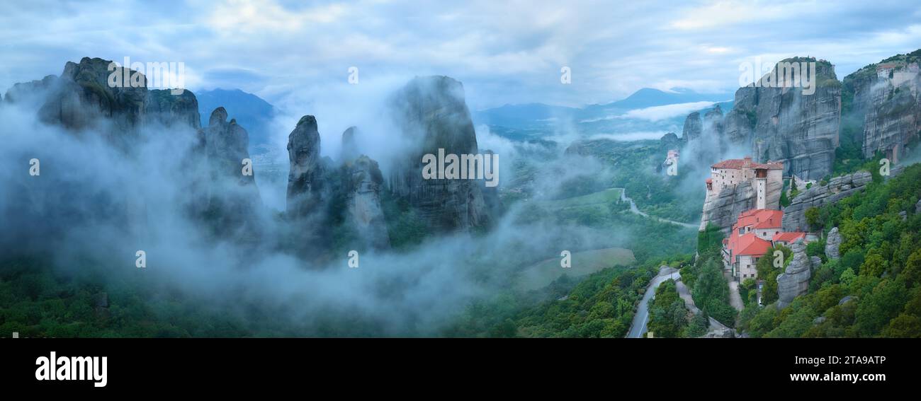 Montagne panoramiche di Meteora e Monastero di Roussanou che si innalzano dalla nebbia. Paesaggio panoramico mistico e aereo. Sito patrimonio dell'umanità dell'UNESCO. GRE Foto Stock