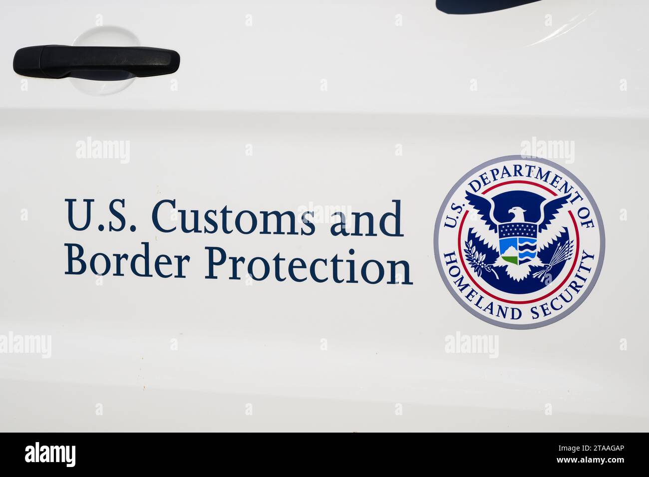 Anacortes, WA, USA - 28 novembre 2023; firma sullo sportello dell'auto per la dogana statunitense e la protezione delle frontiere e badge per il Dipartimento della sicurezza interna degli Stati Uniti Foto Stock