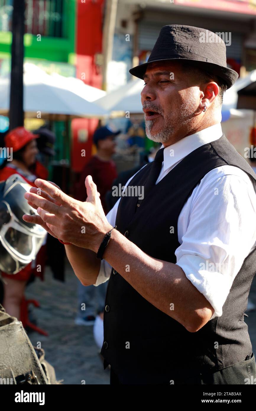 Un ballerino di tango maschile in un abito tradizionale che aspetta che il turista faccia una foto con lui per suggerimenti in via Caminito. La Boca. Buenos Aries. Argentina Foto Stock