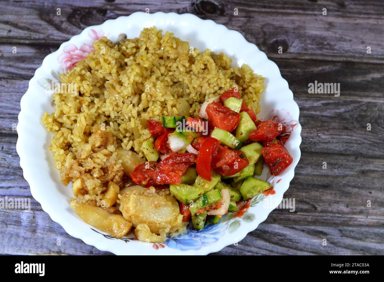 Riso egiziano cucinato a vapore caldo, insalata verde e calamari fritti, un mollusco dal corpo morbido allungato, occhi grandi, otto braccia e due tentacoli Foto Stock