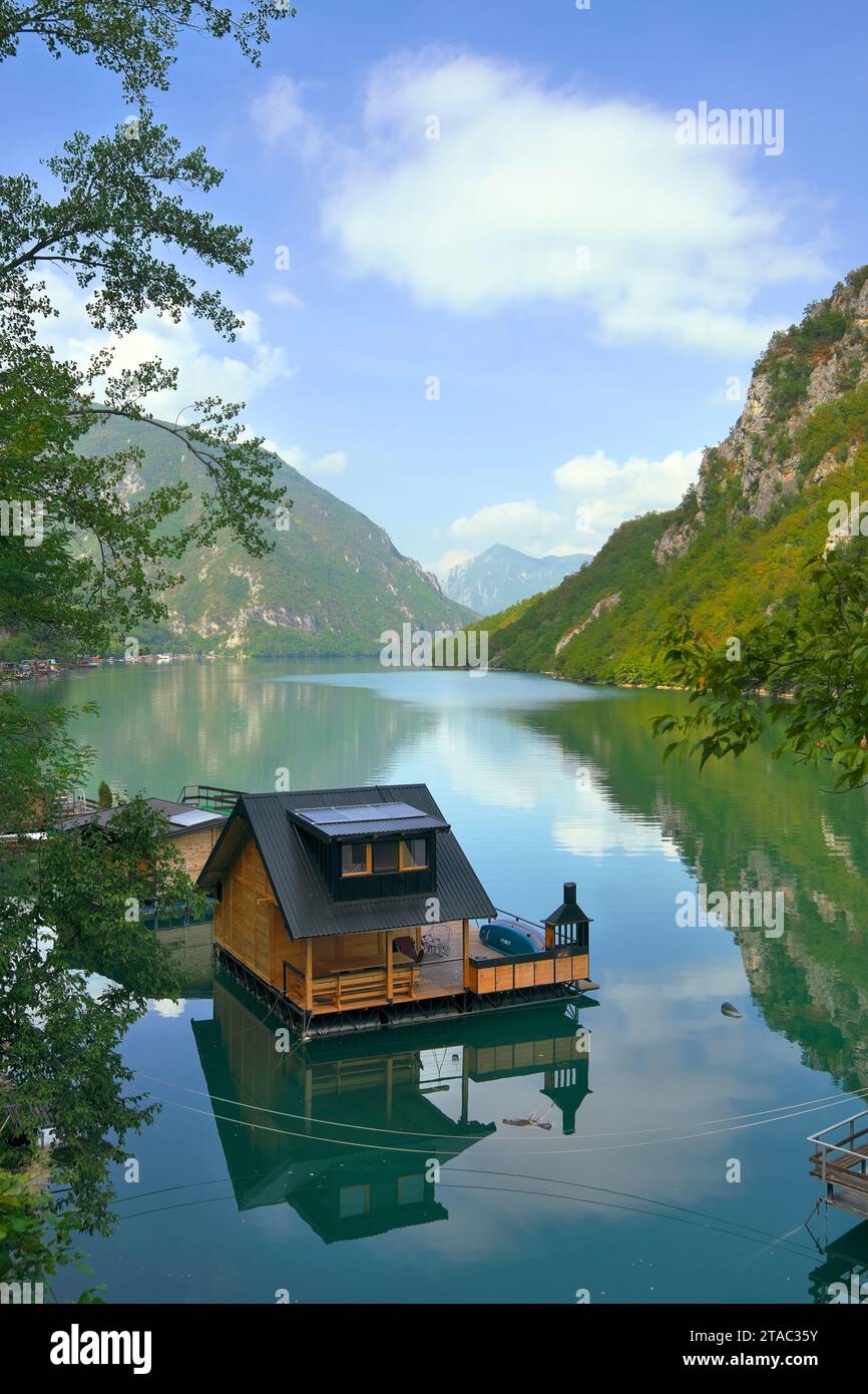 Riflesso di una casa galleggiante sulla superficie dell'acqua del lago Perucac - splendido paesaggio del fiume Drina, Bajina basta, Serbia Foto Stock