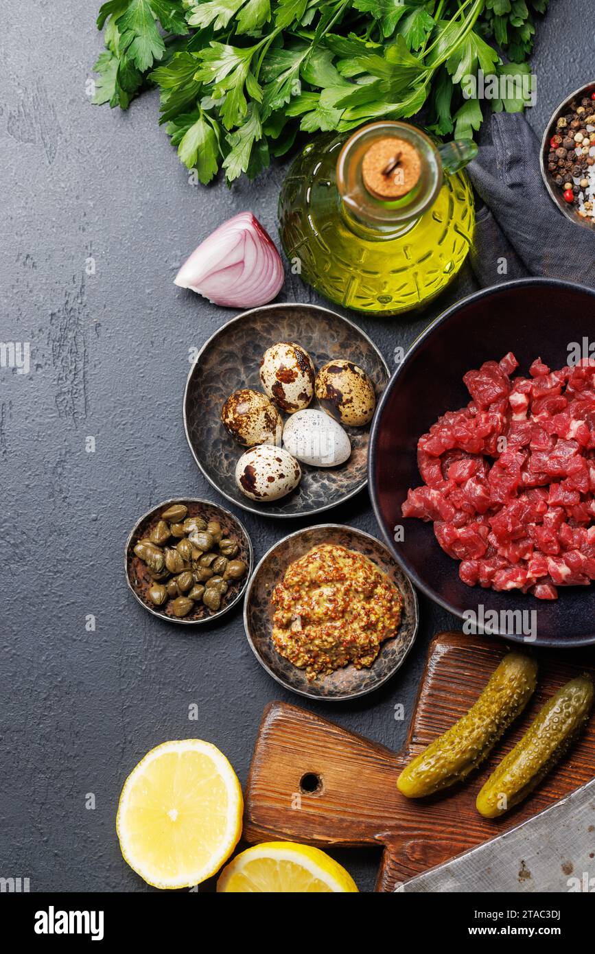 Cottura di una saporita tartare di manzo con cetriolini sottaceto e pane tostato. Base piatta con spazio per la copia Foto Stock