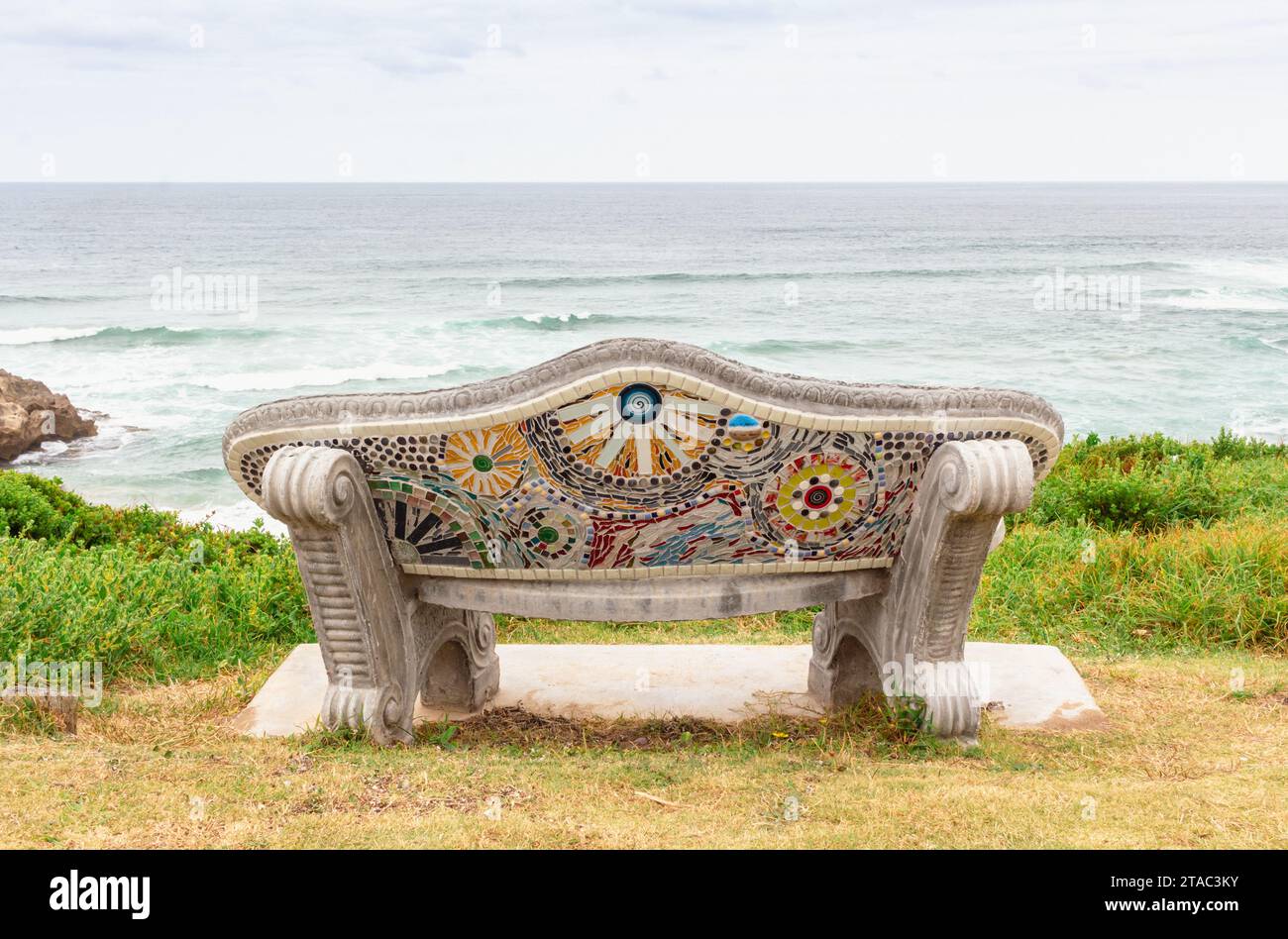 Panca vuota con vista mare - panca decorata con piastrelle a mosaico a colori a Brenton on Sea, Sud Africa Foto Stock