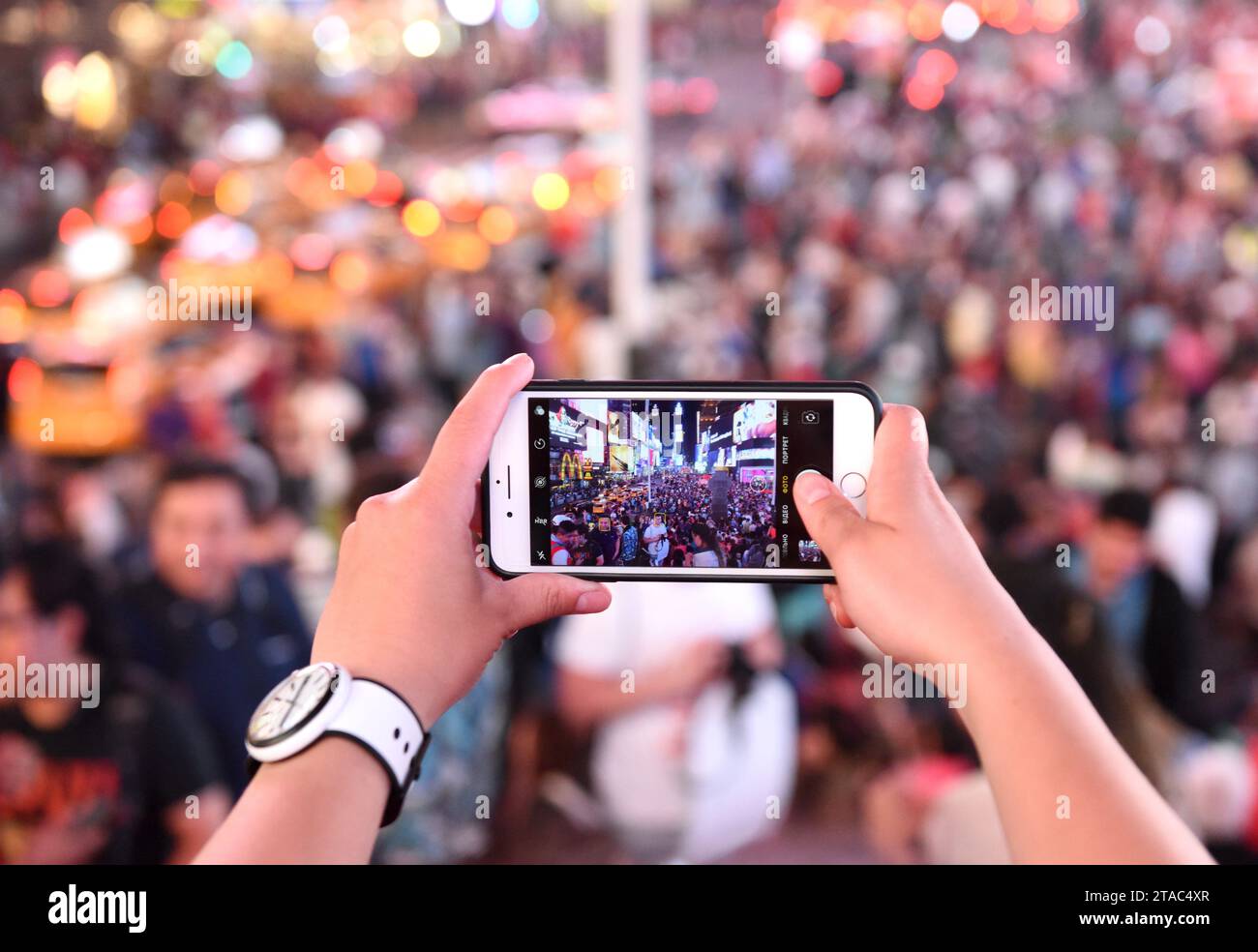 New York, USA - 10 giugno 2018: Una donna fa una foto sul suo iPhone a Times Square a New York. Foto Stock
