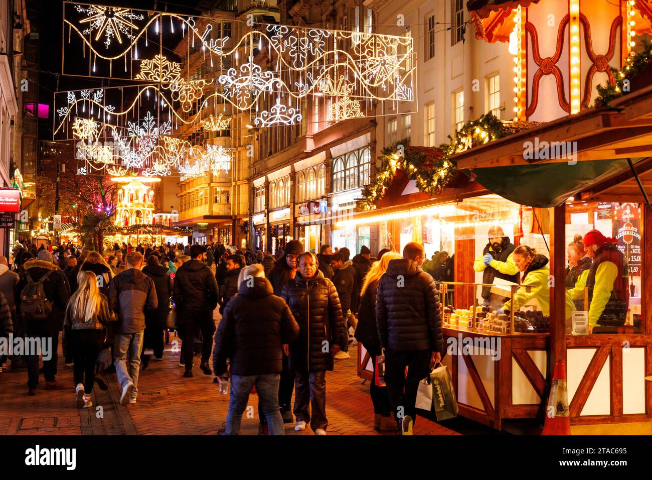 La vista lungo New Street durante il mercato natalizio di Birmingham Francoforte. Il più grande autentico mercatino di Natale tedesco al di fuori della Germania o dell'Austria. Quest'anno l'iconica fontana del centro città "Floozie in the Jacuzzi", inondata di luce rossa e verde, si è unita ad altre attrazioni che accolgono migliaia di visitatori da tutto il mondo. Oltre 100 bancarelle fiancheggiavano le strade principali del centro città e il mercato sarà aperto fino alla vigilia di Natale. Il mercato natalizio di Francoforte di Birmingham offre una vasta gamma di prodotti e regali tradizionali e una selezione di cibi e bevande allettanti. Foto Stock