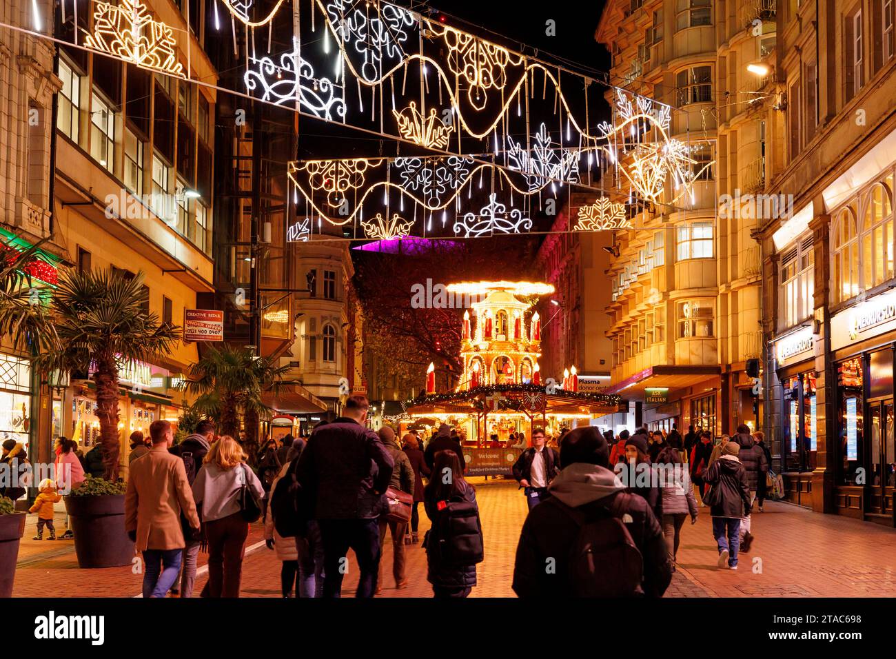 La vista lungo New Street durante il mercato natalizio di Birmingham Francoforte. Il più grande autentico mercatino di Natale tedesco al di fuori della Germania o dell'Austria. Quest'anno l'iconica fontana del centro città "Floozie in the Jacuzzi", inondata di luce rossa e verde, si è unita ad altre attrazioni che accolgono migliaia di visitatori da tutto il mondo. Oltre 100 bancarelle fiancheggiavano le strade principali del centro città e il mercato sarà aperto fino alla vigilia di Natale. Il mercato natalizio di Francoforte di Birmingham offre una vasta gamma di prodotti e regali tradizionali e una selezione di cibi e bevande allettanti. Foto Stock
