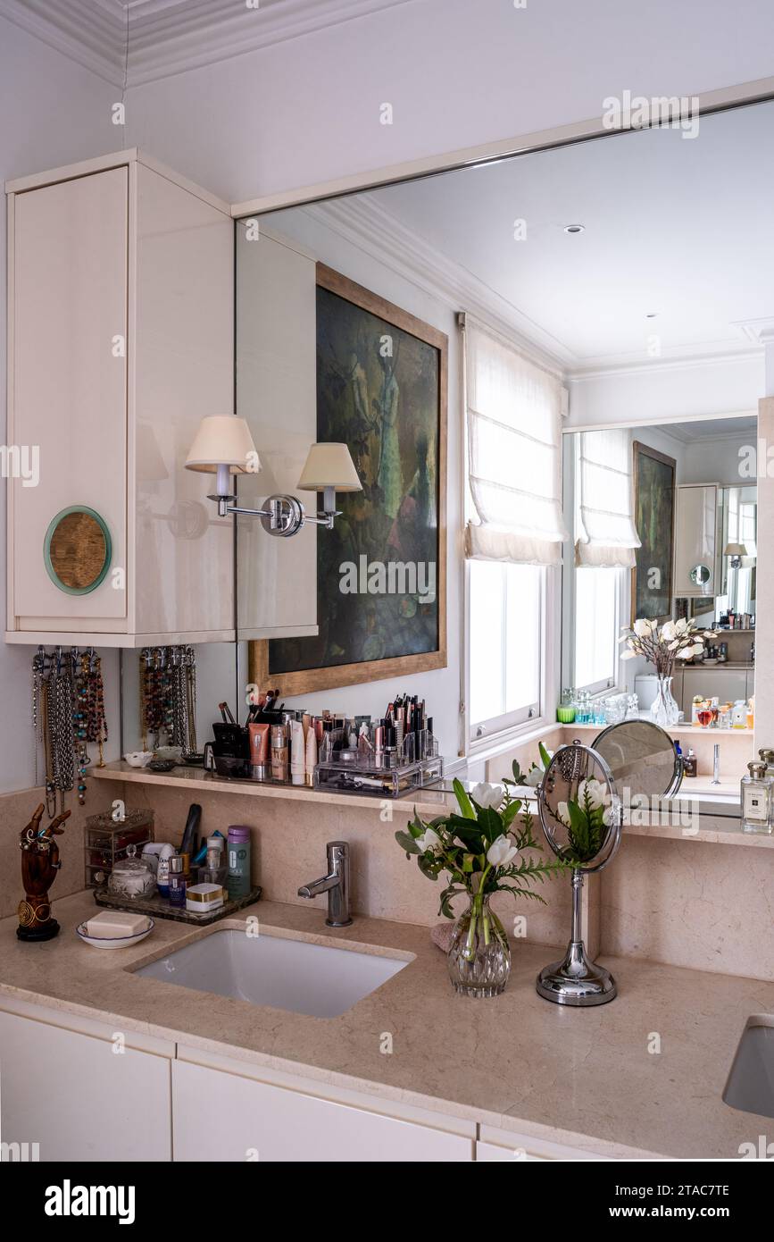 Grande specchio e cosmetici al lavandino nella casa di West London del tardo diciannovesimo secolo. Foto Stock